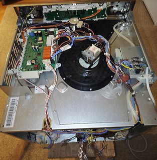Innenansicht eines geöffneten Elektrogeräts mit Platine und Kabeln