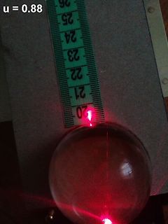 Laserstrahl durch Glaskugel und Lineal
