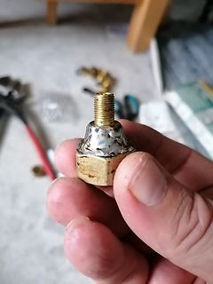 Metallisches Bauteil mit Gewinde in Hand gehalten