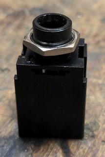 Schwarzer Drucktaster mit Metallmutter