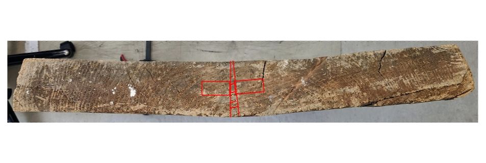 Holzstück mit roten Markierungen