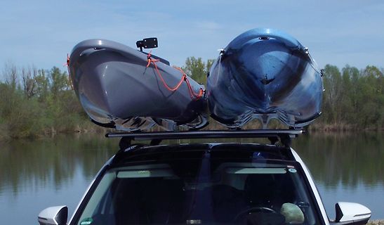 Zwei Kajaks auf einem Autodach vor einem See