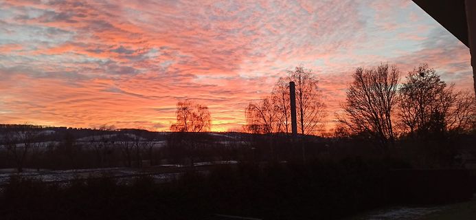 Sonnenuntergang mit Wolken und Bäumen