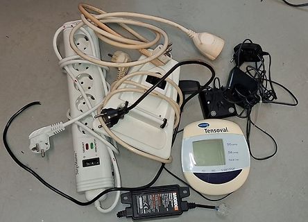 Verschiedene Elektrogeräte und Netzteile auf Boden