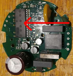 Leiterplatte mit elektronischen Bauteilen und rotem Pfeil