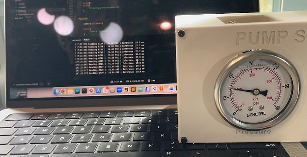 Laptop mit Programmcode und Druckmessgerät