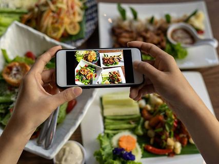 Person fotografiert Essen mit Smartphone