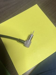Stecker eines Messkabels auf gelbem Papier