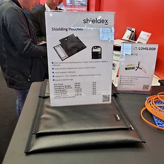 Werbeaufsteller für Shieldex Abschirmtaschen auf einem Messestand