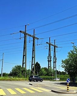 Strommasten und Oberleitungen unter blauem Himmel