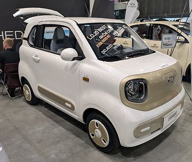 Weißes Mini-Elektroauto auf einer Messe