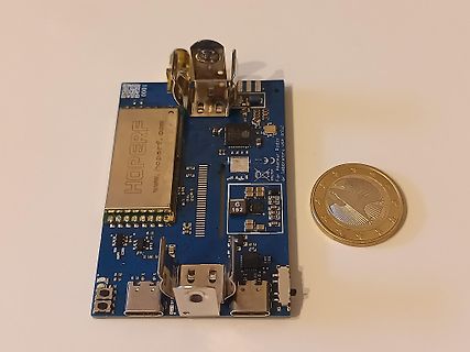 Blaues PCB mit Metallgehäuse und Euro-Münze zum Größenvergleich