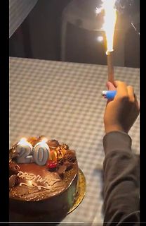 Schokoladenkuchen mit Kerzen und brennendem Feuerzeug
