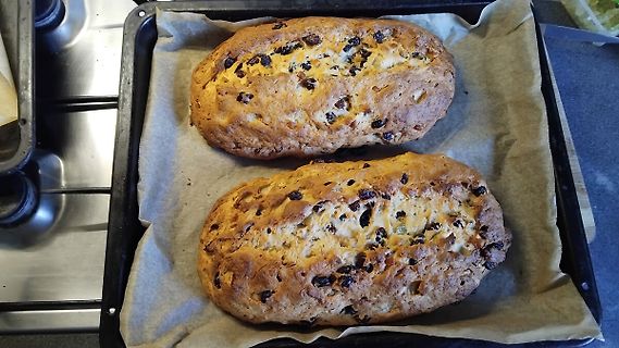 Zwei frisch gebackene Brotlaibe auf Backpapier