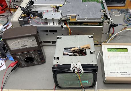 Elektronik-Werkstatt mit Multimeter, Messgerät und geöffnetem Gerät