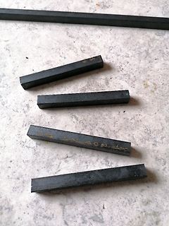 Dunkle rechteckige Metallstäbe auf hellem Untergrund