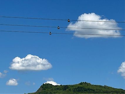 Stromleitungen vor blauem Himmel und Wolken