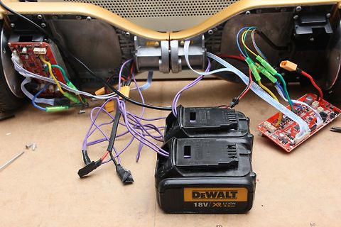 Elektronikkomponenten, Kabel und DeWalt Akkus auf Werkstattuntergrund