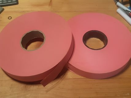 Zwei Rollen rosa Papier auf Holztisch