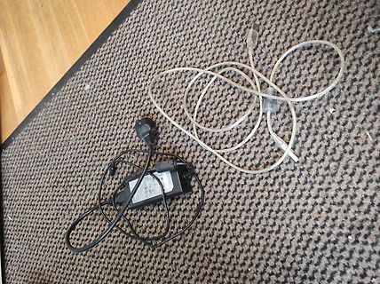 Netzteil mit Kabel auf Teppich