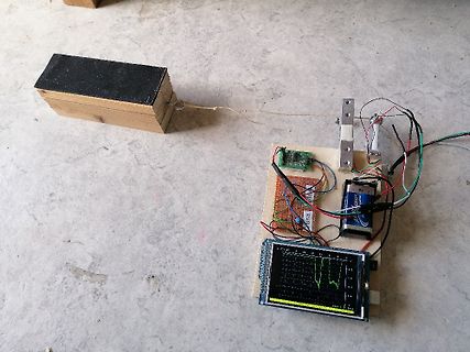 Elektronik-Versuchsaufbau mit Display, Batterie und Holzbrett