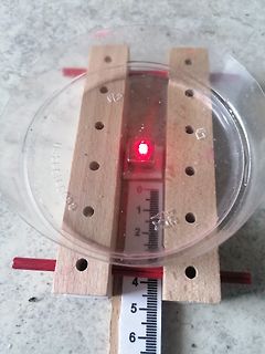 Aufbau mit roter LED und Lineal auf Holzleisten