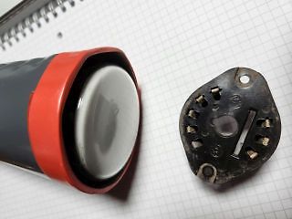 Geöffnetes Gehäuse und Bauteil auf kariertem Papier