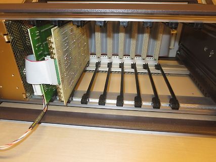 Innenansicht eines elektronischen Geräts mit Leiterplatte und Flachbandkabel