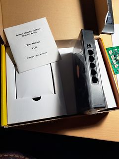 Inhalt eines Kartons mit Sempre Ethernet Switch und Handbuch