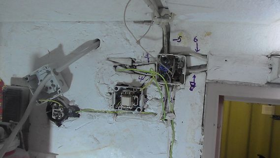 Defekte elektrische Installation an einer Wand