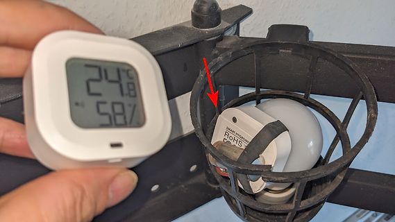 Digitales Thermometer neben einer Lampe