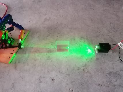 Optischer Versuchsaufbau mit Laserstrahl und Glasblock