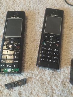 Zwei FRITZ!Fon Mobilteile auf Teppich