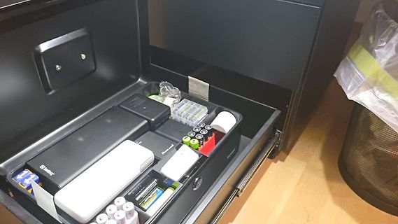 Offene Schublade mit Elektronikzubehör und Batterien