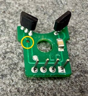 Foto eines kleinen grünen PCB mit zwei schwarzen Bauteilen