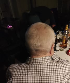 Rückenansicht einer Person am Tisch mit Getränken