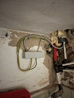 Elektroinstallation und Rohre in einer Wandöffnung