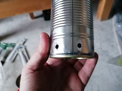 Metallene Dose mit Löchern in der Hand gehalten
