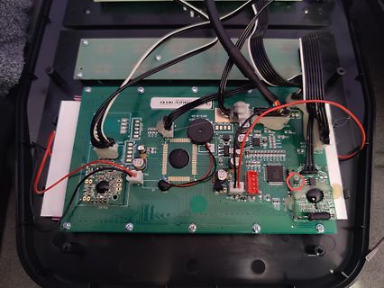 Geöffnete Elektronik mit Leiterplatte und Kabeln