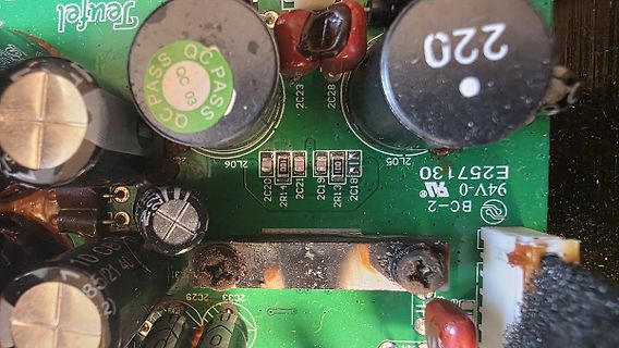 Nahaufnahme einer beschädigten Leiterplatte mit Elektrolytkondensatoren