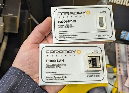Zwei Faraday Defense Filteradapter in einer Hand