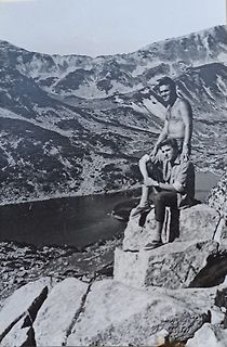 Zwei Personen in einer Berglandschaft vor einem See
