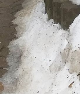 Schneehaufen auf Pflastersteinen