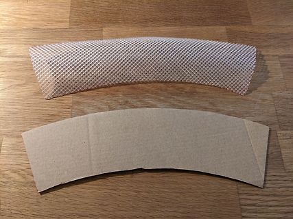Gittergewebe und Pappe auf Holzuntergrund