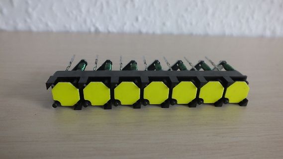 Reihe gelber Bauteile mit grünen Spulen