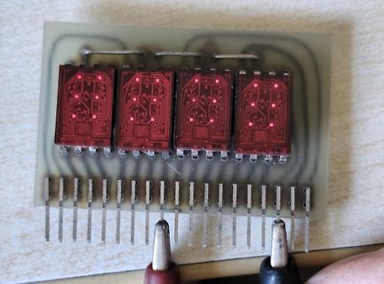 Vier rote IC-Gehäuse auf einer Leiterplatte