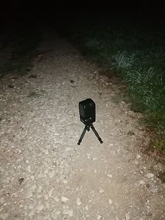 Ein schwarzes Gerät auf einem Stativ auf einem Kiesweg