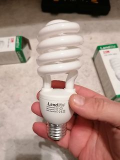 Hand hält eine Landlite Kompaktleuchtstofflampe