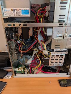 Innenansicht eines Computergehäuses mit Netzteil und Kabeln