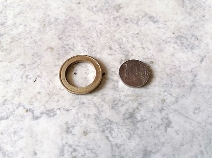 Ring und Münze auf Marmoroberfläche